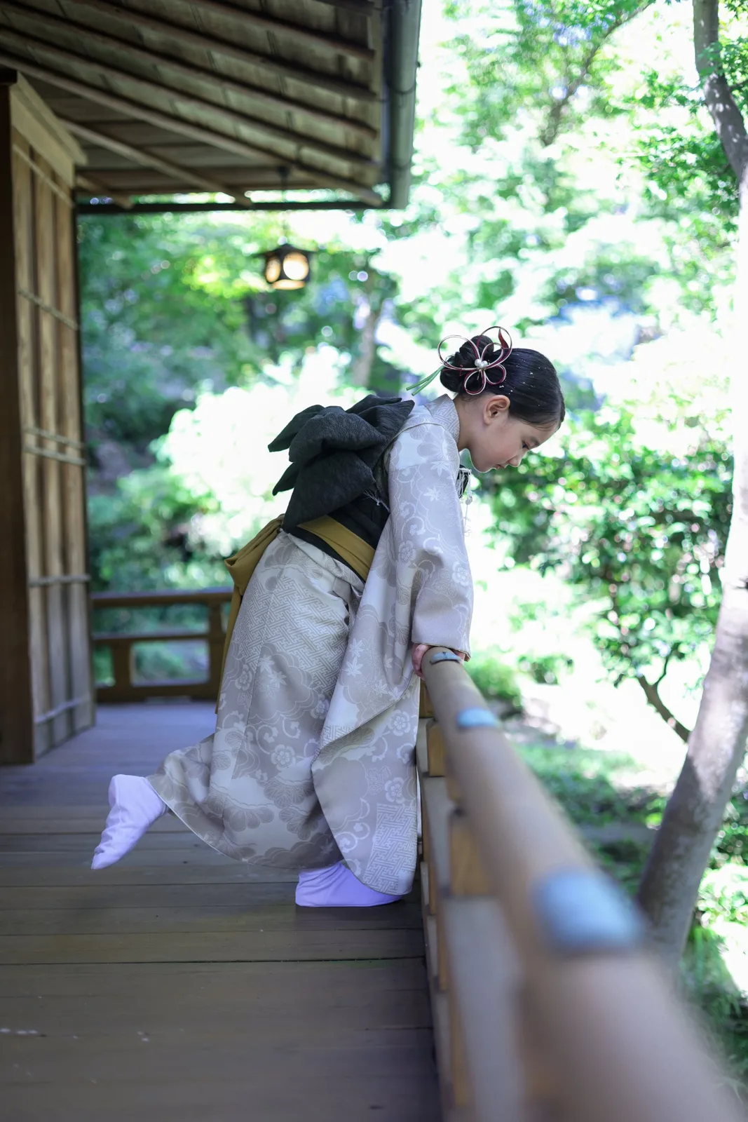 茶室の縁側の手すりから、庭をのぞきこむお子さま