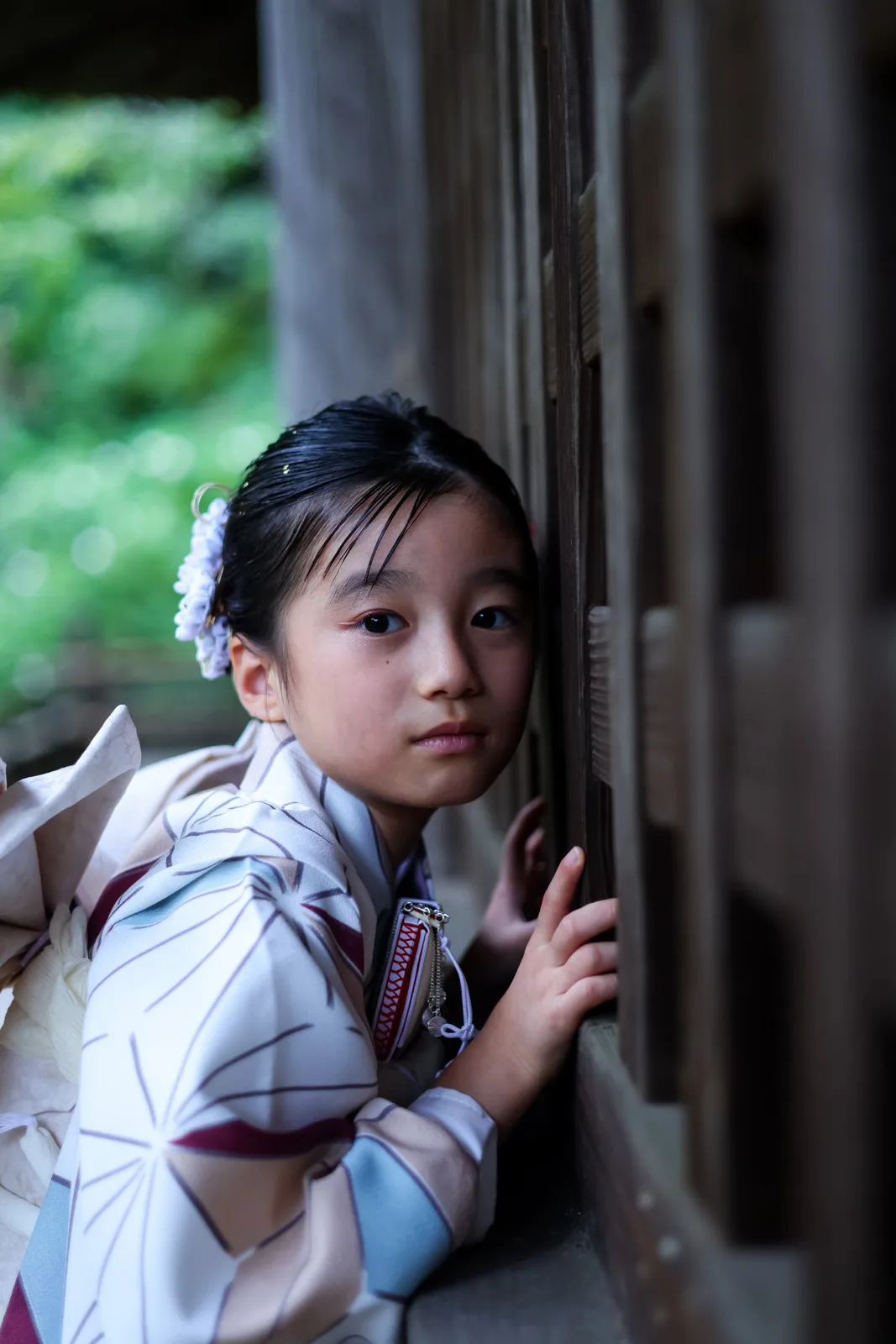 お堂の格子に寄りかかって、こちらを見るお子さま