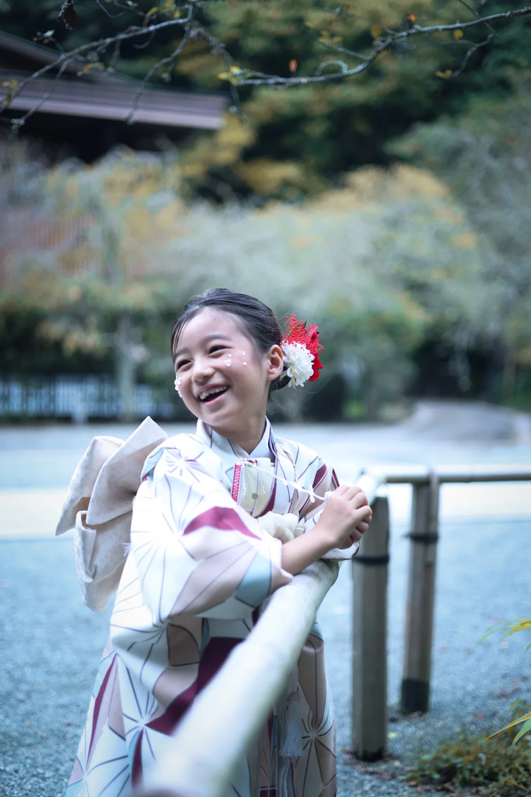 竹の柵につかまって笑うお子さま