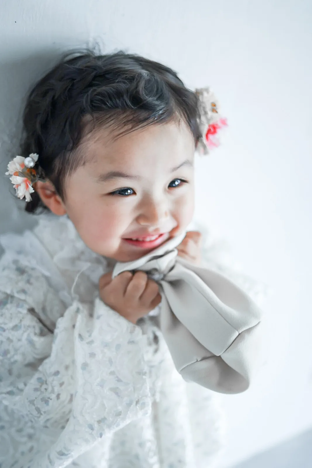 巾着を抱えて笑う、3歳の女の子