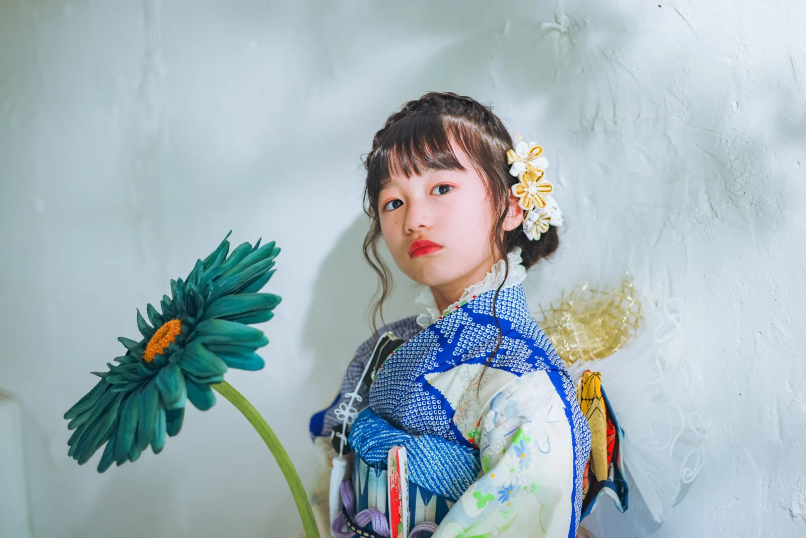 大きな花を手に、こちらを見る七五三の女の子