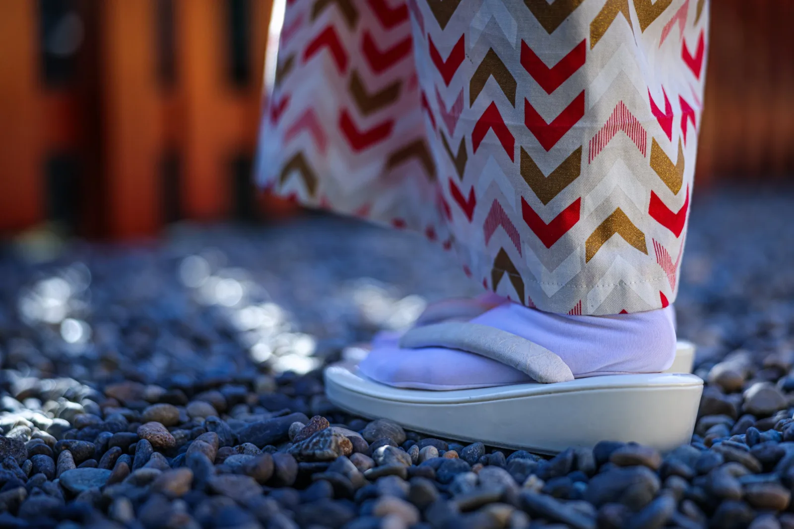 境内の砂利の上に立つ草履の足もと
