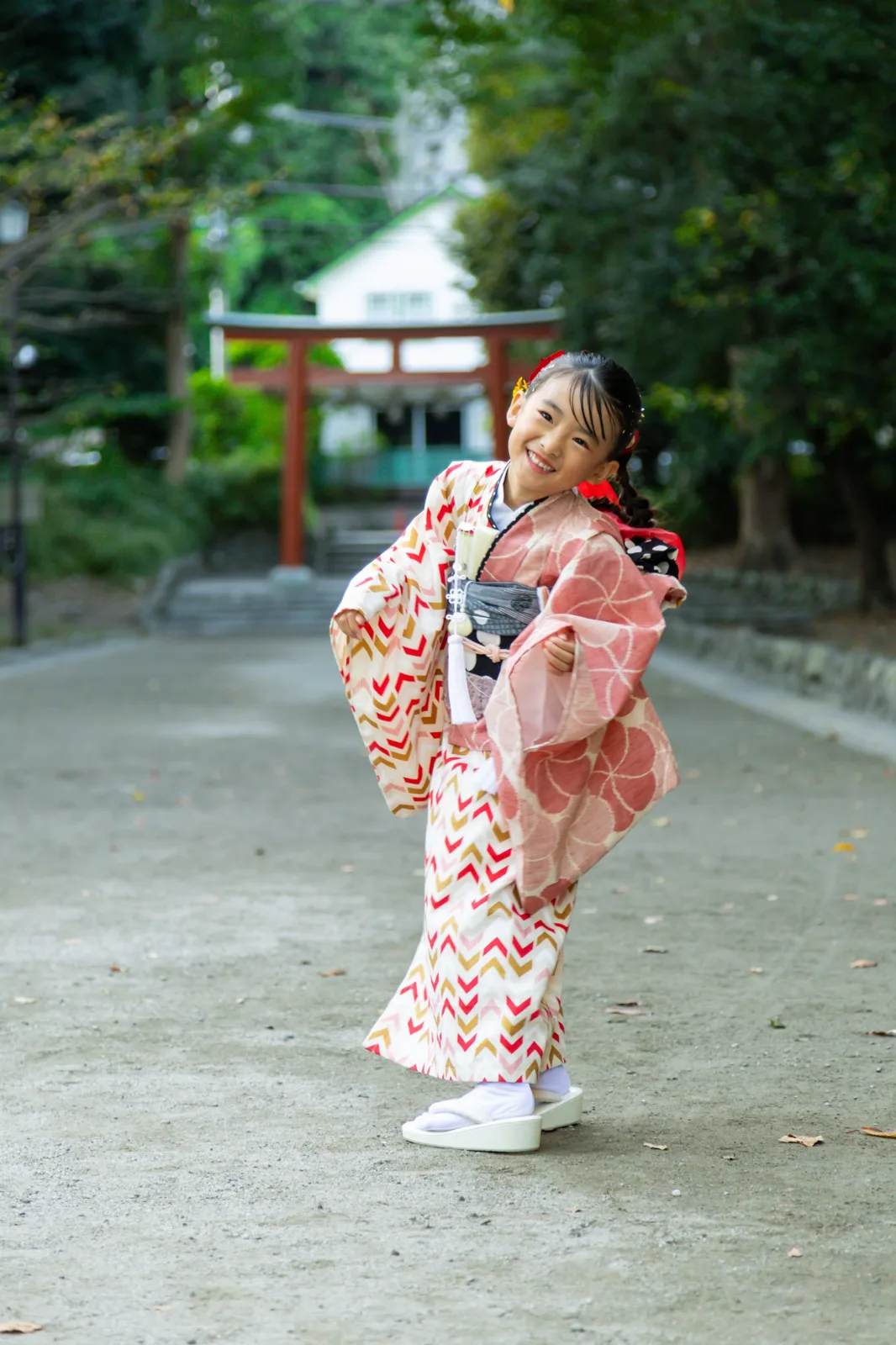 鳥居の前の参道で、着物の袖を広げて笑うお子さま