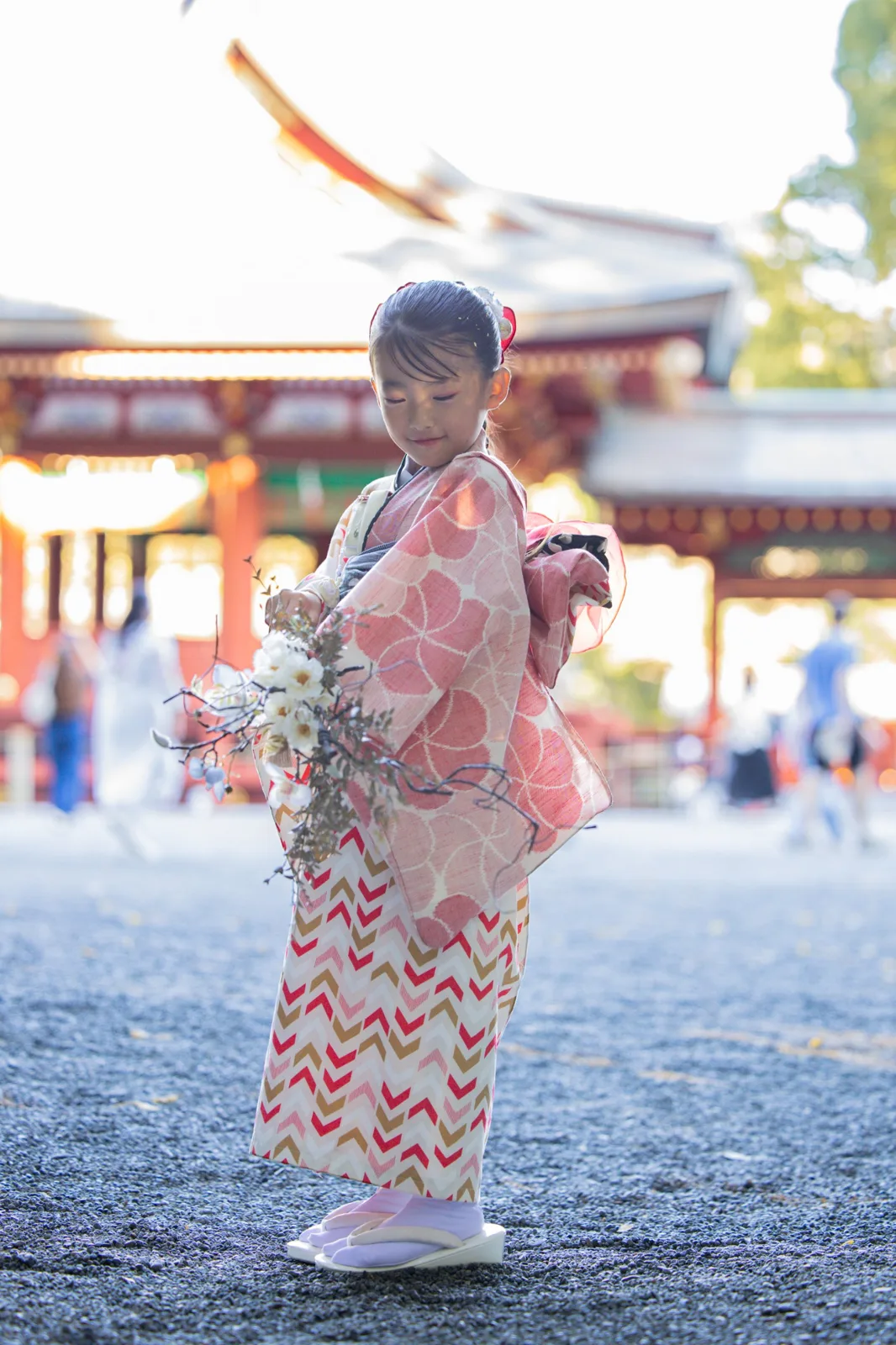 舞殿の前の境内で、花を手にするお子さま